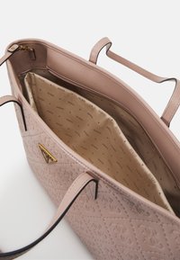 Borsa a tracolla rosa trapuntata con esterno in pelle liscia, dotata di accessori in oro e fodera interna beige con un motivo a logo ripetuto.