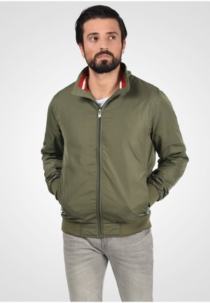 Olive green bomber jacket with a zip front, ribbed knit cuffs, and collar featuring red and white stripes. Textured finish, slim fit.