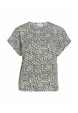 Blouse à manches courtes avec des pois noirs irréguliers sur un tissu blanc, encolure ronde et coupe décontractée.