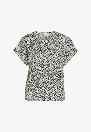 Kortærmet bluse med sorte uregelmæssige polkaprikker på hvidt stof, rund halsudskæring og løs pasform.