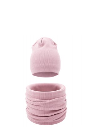 Jasnoróżowa prążkowana dziana czapka beanie i pasujący komin na szyję, pokazane na białym tle.