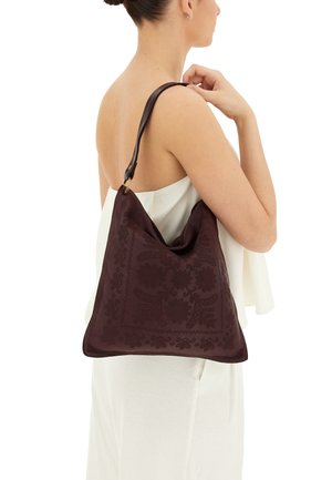 Borsa a spalla in pelle bordeaux con motivi floreali in rilievo, forma snella e morbido al tatto. Dettagli in metallo dorato.