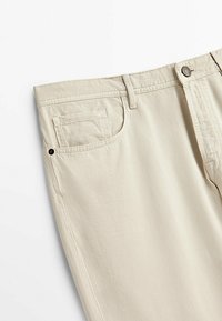 Beiga bomullskalsonger med rak passform. Har en framfick, knappstängning och subtil textur.