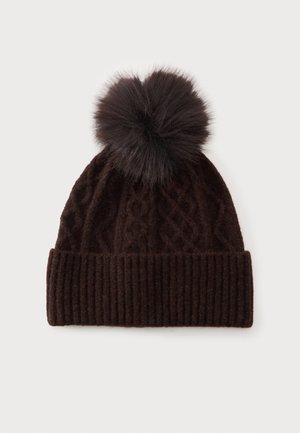 Gorro de invierno de punto marrón oscuro con un amplio puño acanalado y un gran pompón esponjoso en la parte superior, sobre un fondo claro liso.