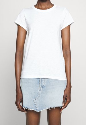 Witte katoenen T-shirt met korte mouwen en een ronde hals, gecombineerd met een lichtblauwe denim mini rok met een rafelige zoom en stikseldetails.