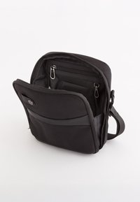 Sort stof messenger tas med en lynlåset hovedrum, multiple indvendige lommer og en justerbar rem. Tekstur overflade.
