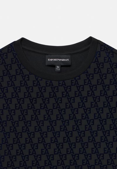 Melns kokvilnas T-krekls ar visaptverošu tumši zilu EA logotipa rakstu. Klasicks apaļais kakls ar gludu tekstūru. Redzams zīmola nolikums.