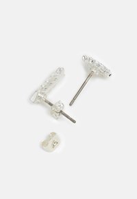 Transparent resin earrings in a floral shape with silver-tone metal posts, featuring a clip back for secure wear.
