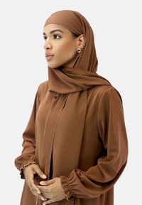 Brun hijab og matchende bluse med lange ærmer lavet af glat stof. Blusen har en frontåbning og samlede manchetter med lette udsmykninger.