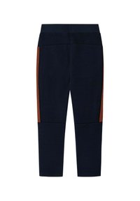 Námornícke modré legíny s vysokým pásom a vertikálnymi oranžovými pruhmi, ktoré prebiehajú pozdĺž vonkajších strán nôh.