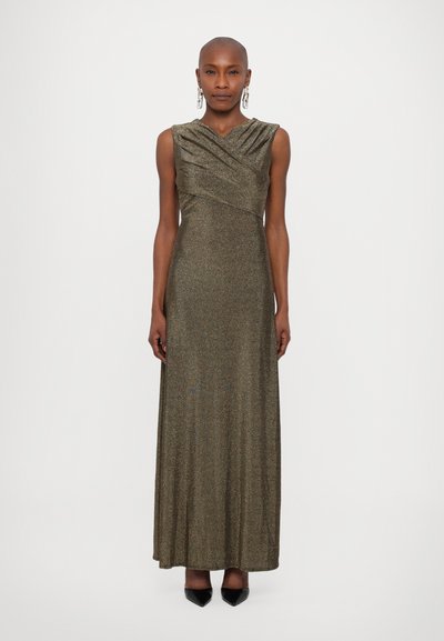 Robe de soirée dorée scintillante avec un corsage ajusté, un col drapé, sans manches et une jupe longue, associée à des talons noirs.