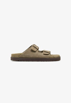Bruine nubuck slidesandalen met twee verstelbare gespen, een platte zool en subtiele logo-opdruk aan de zijkant.