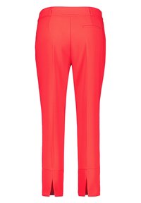 Pantalon ajusté rouge avec une texture lisse, comprenant une taille mi-haute, une poche arrière et des fentes latérales à l'ourlet pour plus de détails.