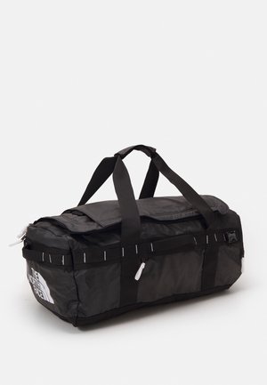 Czarna prostokątna torba typu duffel z podwójnymi uchwytami do noszenia, główną komorą zapinaną na zamek błyskawiczny oraz logo The North Face na jednym końcu.