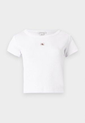 Biała prążkowana koszulka z krótkimi rękawami i okrągłym dekoltem. Na piersi znajduje się małe prostokątne logo CK w kolorach czerwonym i czarnym.