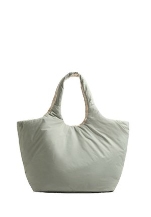 Hellgrüne, gepolsterte Tragetasche mit weitem Eingang und doppelten Tragegriffen. Innenfutter in kontrastierendem Beige, glatte Textur.