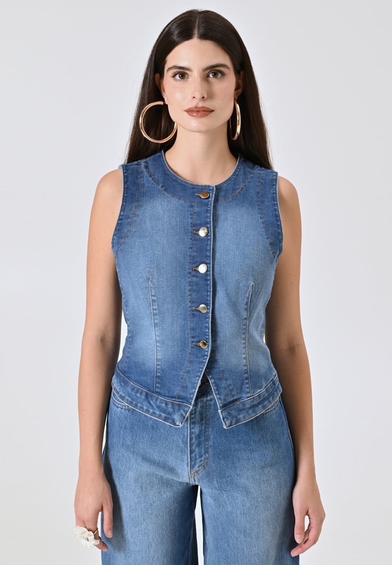 Gilet in denim con un design aderente, senza maniche e cinque bottoni frontali. Colore azzurro chiaro con sfumature sottili e dettagli di cucitura a contrasto.