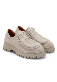 Chaussures en suede beige avec des accents moelleux, présentant un bout arrondi, une semelle épaisse et striée, et trois œillets métalliques pour les lacets.