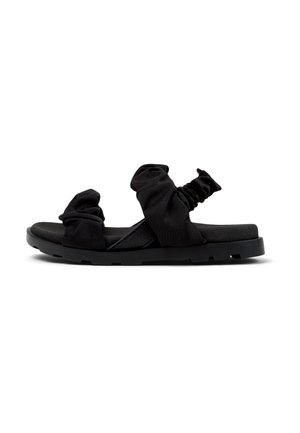 Svarta platta sandaler med samlad tygremmar, en strukturerad fotbädd och en robust gummisula med ett mönster för grepp.