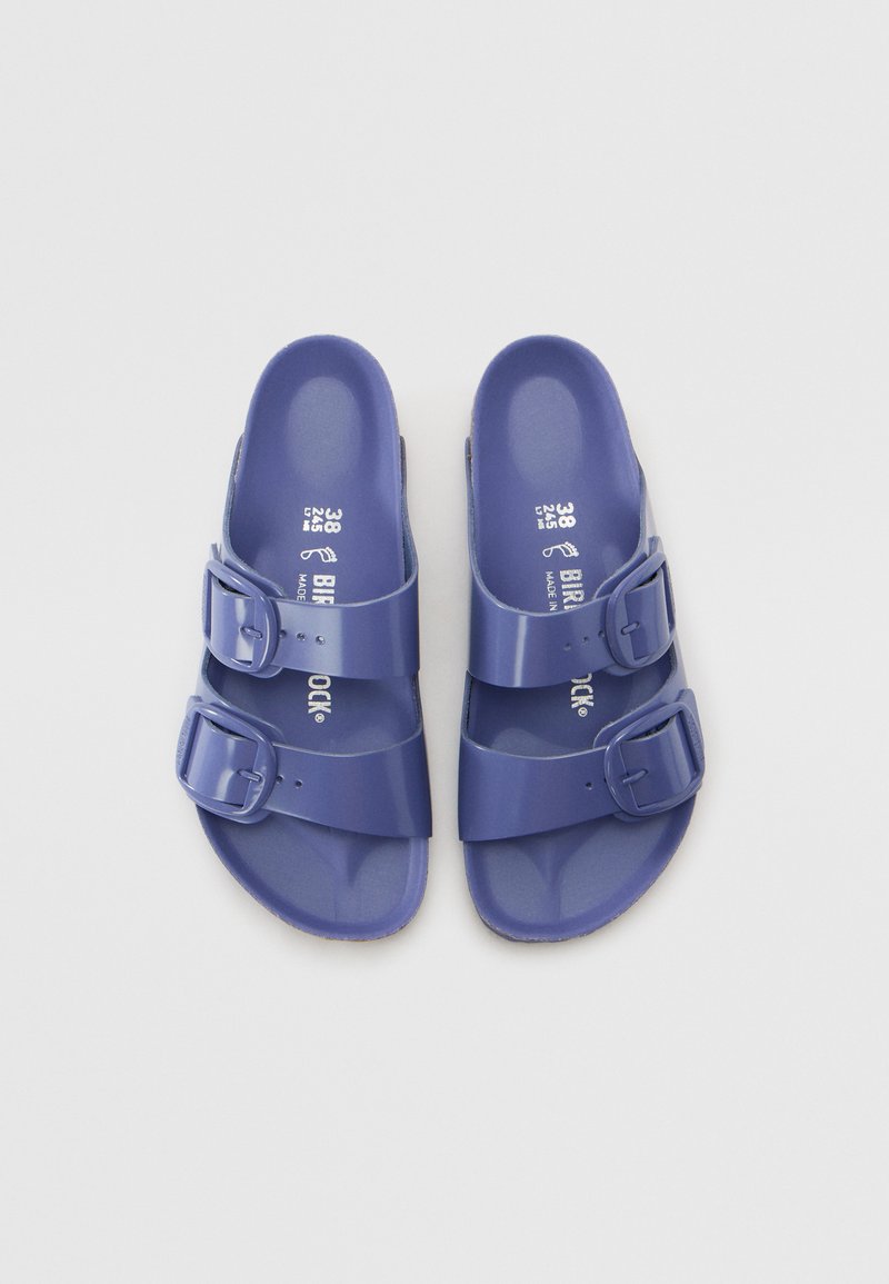 Lila Kunststoffsandalen mit zwei verstellbaren Schnallenriemen, strukturiertem Fußbett und glatter Oberfläche, gekennzeichnet mit Größen- und Markeninformationen.