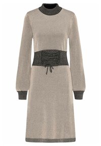 Abito in maglia con maniche lunghe, collo alto e vita arricciata nera. Il colore principale è beige con accenti metallici e dettagli in bordo scuro.