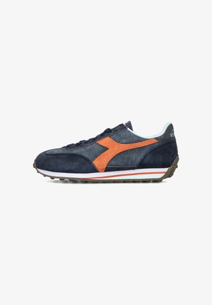 Navy suede sneaker with orange accents, textured upper, white midsole, and rubber outsole. Features a rounded toe and lace-up design.