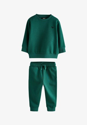 Zöld, két részes szett, amely egy hosszú ujjú, kerek nyakú pulóverből és egy hozzátartozó, rugalmas derékpántos melegítőnadrágból áll.