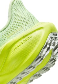 Chaussure de sport vert vif avec une tige en mesh texturée et une semelle rembourrée. Dotée d'une marque "Air Zoom" bien visible et d'une semelle extérieure en caoutchouc durable.