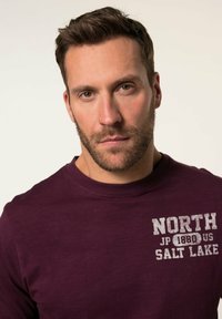 Bordová dlouhá rukáv tričko s žebrovaným kulatým výstřihem. Na přední straně je bíle potištěný text "NORTH JP 1880 US SALT LAKE". Měkká textilie.