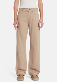 Beige wijde broek van een katoenmix met een soepele textuur, voorzien van voorzakken en een knoopsluiting.