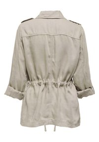 Chaqueta de mezcla de algodón en beige claro, con cintura fruncida, mangas enrollables, hombreras y detalle de yugo en la parte posterior.