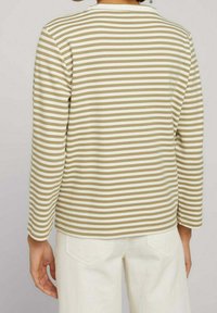 Haut à manches longues rayé avec des lignes alternées beige et blanc, tissu texturé, encolure ronde et coupe décontractée.