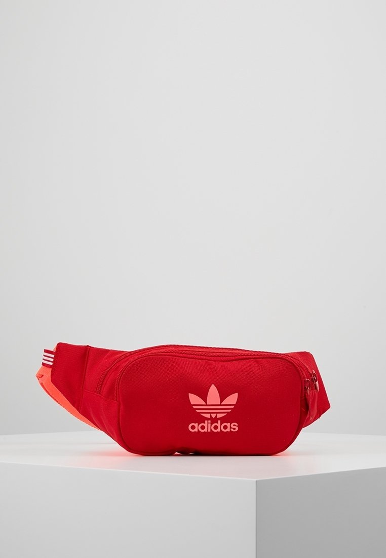 Červená ledvinka Adidas vyrobená z odolného materiálu, s dvoubarevným designem a oranžovými akcenty, předním zipem a logem.