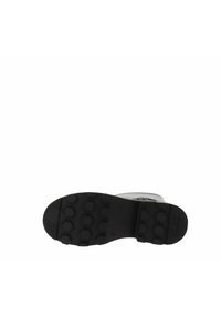 Suela de bota negra con un patrón de banda de rodadura hexagonal, que muestra una base de goma duradera diseñada para ofrecer tracción y estabilidad.