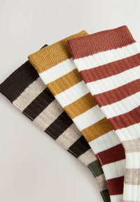 Three pairs of socks feature bold stripes in colors: brown, mustard yellow, and rust red, with ribbed texture and varying widths.
