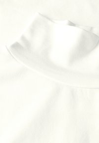 Witte ribstof met een nep-turtleneck ontwerp, met een gladde textuur en een nette afwerking. Subtiele plooi aan de halslijn zichtbaar.