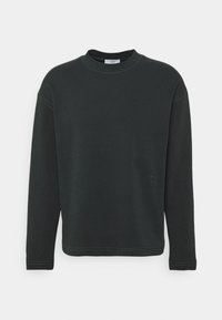 Sweatshirt manches longues vert foncé avec un col ras du cou, présentant des poignets côtelés, des accents de couture et un petit logo en détail sur l'ourlet.