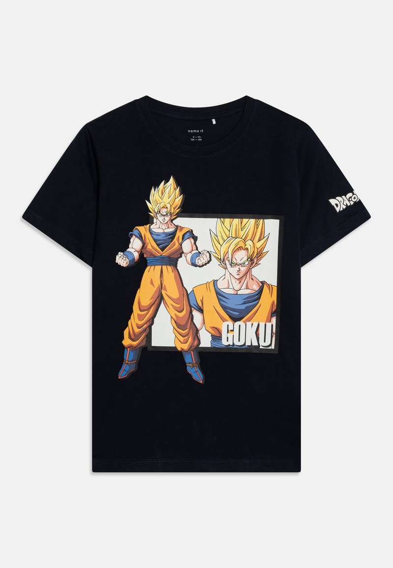 T-shirt en coton noir avec un imprimé graphique de Goku en tenue orange et bleue, avec des cheveux jaunes en pointes sur un fond clair.