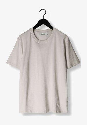 Světle šedé tričko s krátkým rukávem vyrobené z bavlny, vystavené na černém ramínku. Má kulatý výstřih a volný střih.