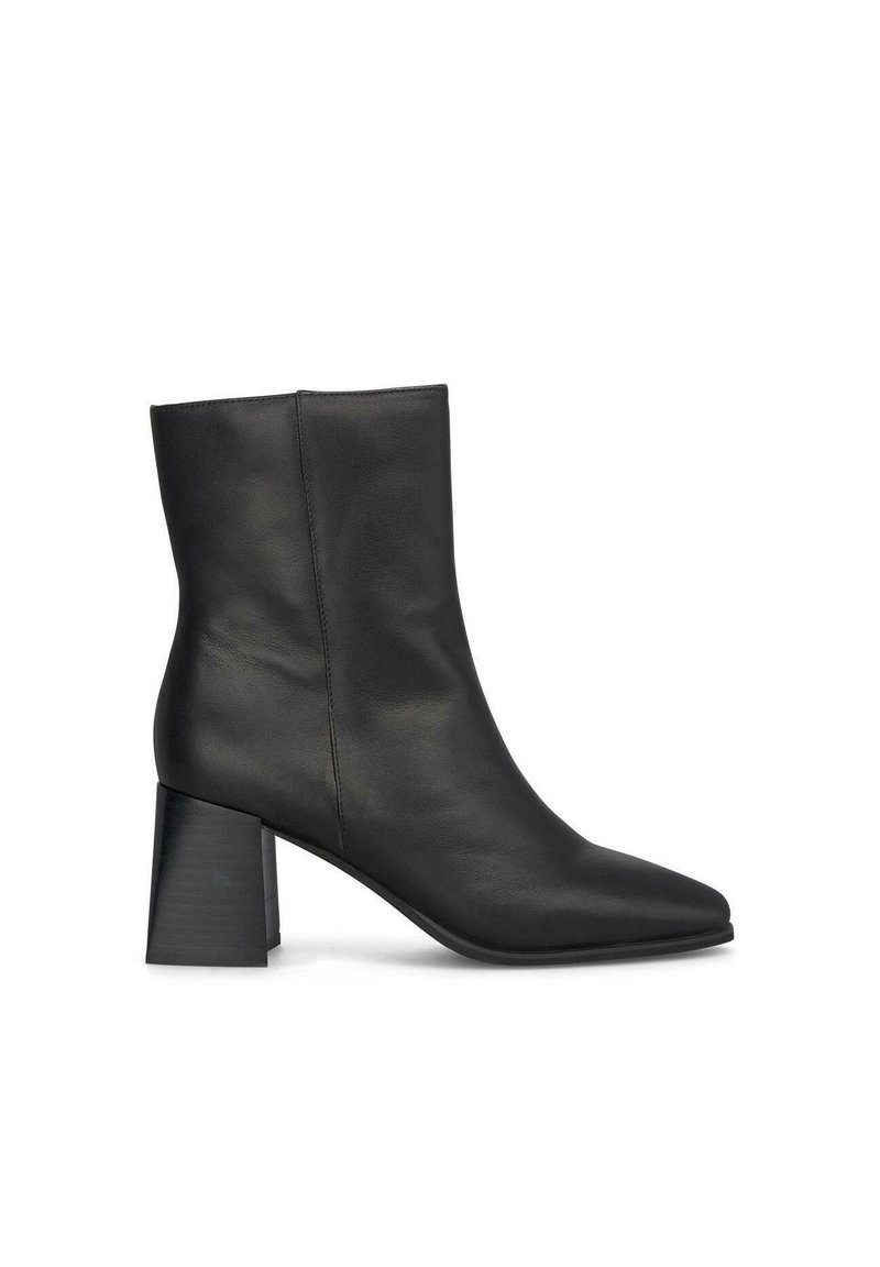 Bottine en cuir noir avec un bout pointu et un talon épais. Texture lisse avec un design minimaliste et sans matériel ou accents visibles.