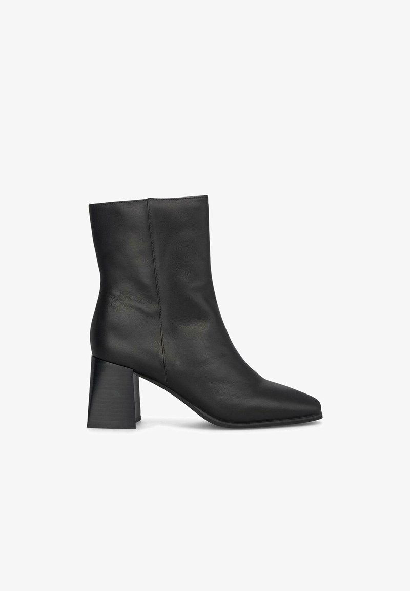 Stivale alla caviglia in pelle nera con punta affusolata e tacco spesso. Texture liscia con design minimalista e senza hardware o accenti visibili.