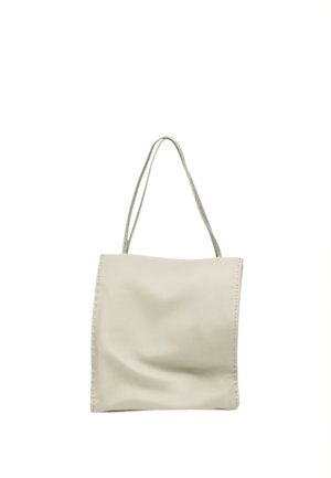 Sac cabas en cuir souple couleur crème avec de fines anses d'épaule et des coutures visibles le long des bords sur fond blanc.