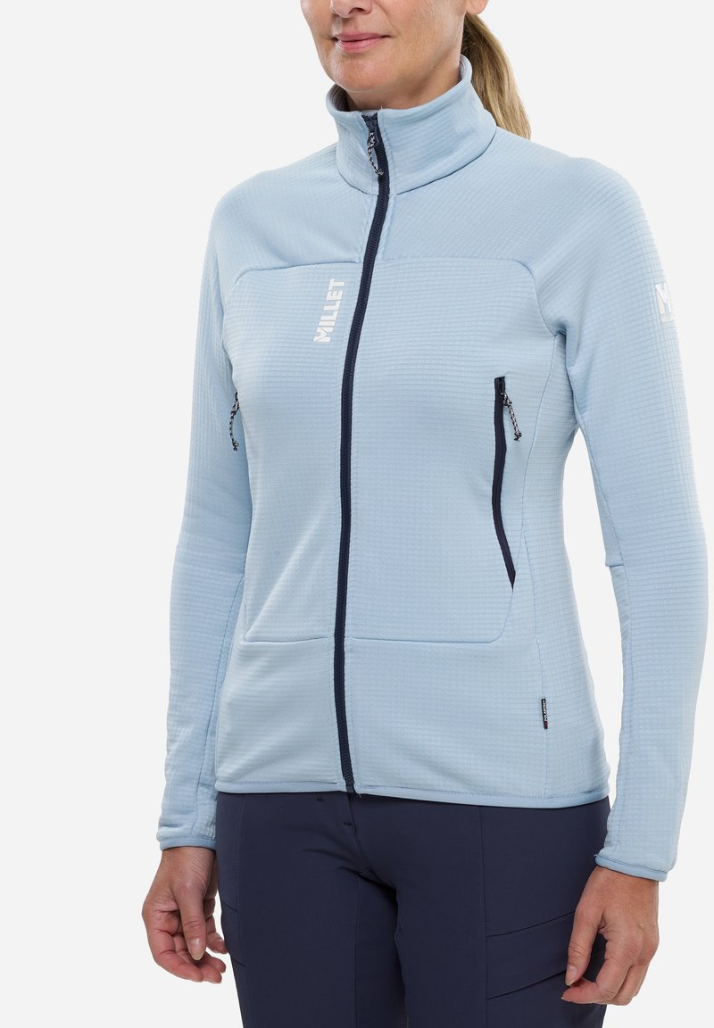 Helle blaue Fleecejacke mit hohem Kragen, ausgestattet mit einem strukturierten Muster, navyfarbener Reißverschluss und zwei seitlichen Reißverschlusstaschen.