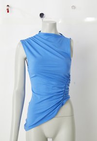 Top bleu fără mâneci, realizat dintr-un material elastic; prezintă un design drapat cu plisare laterală și o linie a marginii diagonale pentru o siluetă ajustată.