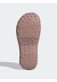 Hellrosa Sneaker-Sohle mit strukturiertem Grip, ausgestattet mit kreisförmigen Mustern, Logo an der Ferse und glatten Oberflächendetails.