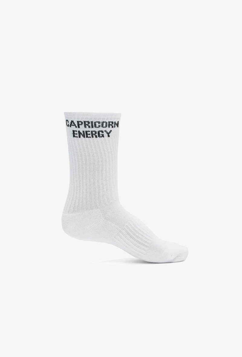 Valge puuvilla seguga sokk ribakujundusega, millel on must "CAPRICORN ENERGY" tekst ääres. Üheksapaikne disain.