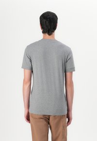 Grijs T-shirt met korte mouwen en een ronde halslijn, gemaakt van een zachte, gladde stof. De achterkant heeft een eenvoudig, strak ontwerp zonder zichtbare logo's.