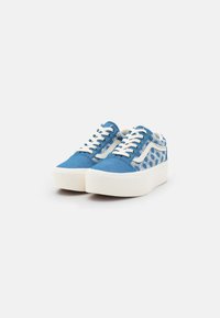 Blue canvas sneakers with white textured accents, round toe, flat laces, and a thick white platform sole. Dotted pattern on back.
