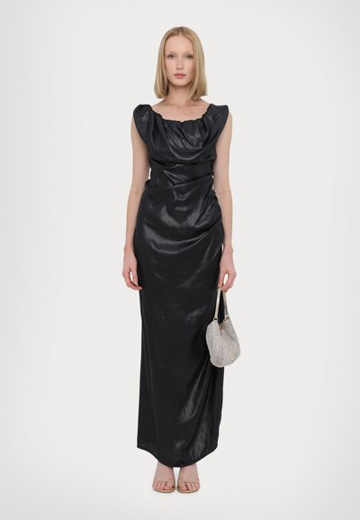 Black, form-fitting maxi dress with a draped neckline and ruffled shoulders. Accompanied by a small silver purse and nude sandals.