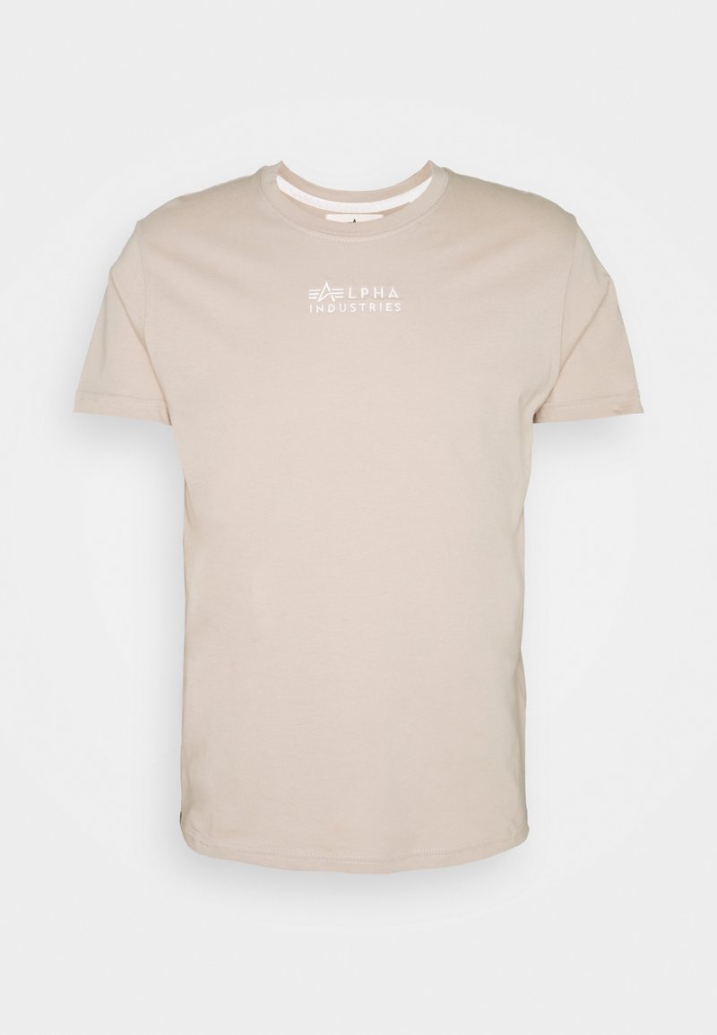 Béžové bavlněné tričko s kulatým výstřihem a krátkými rukávy. Na hrudi má bílé logo "ALPHA INDUSTRIES". Hladká textura.